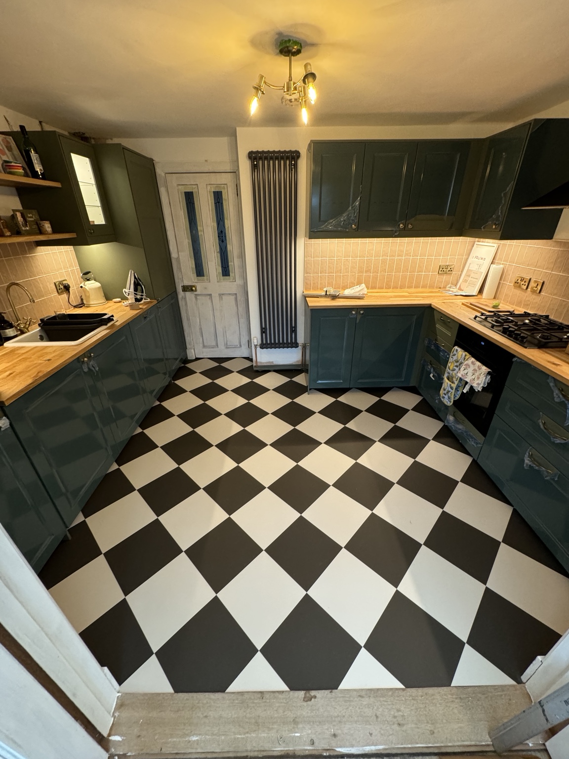 Black and white checkerboard flooring fitted in a domestic kitchen