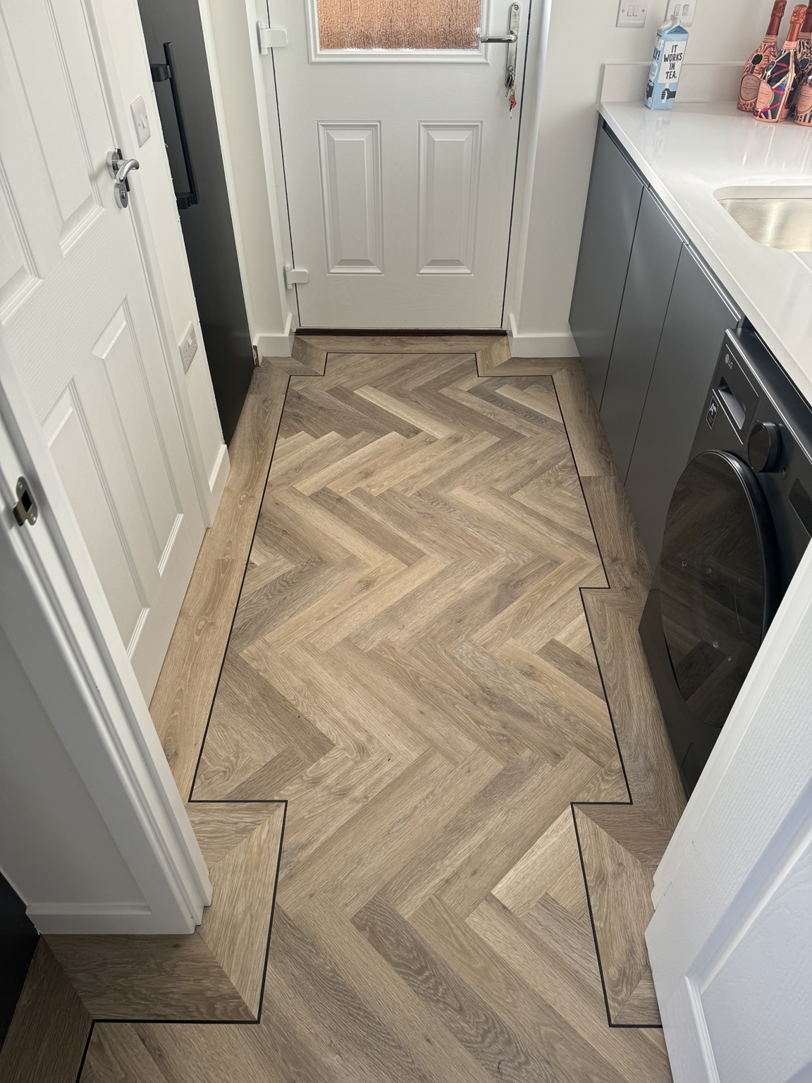 Herringbone LVT installation with a detailed border