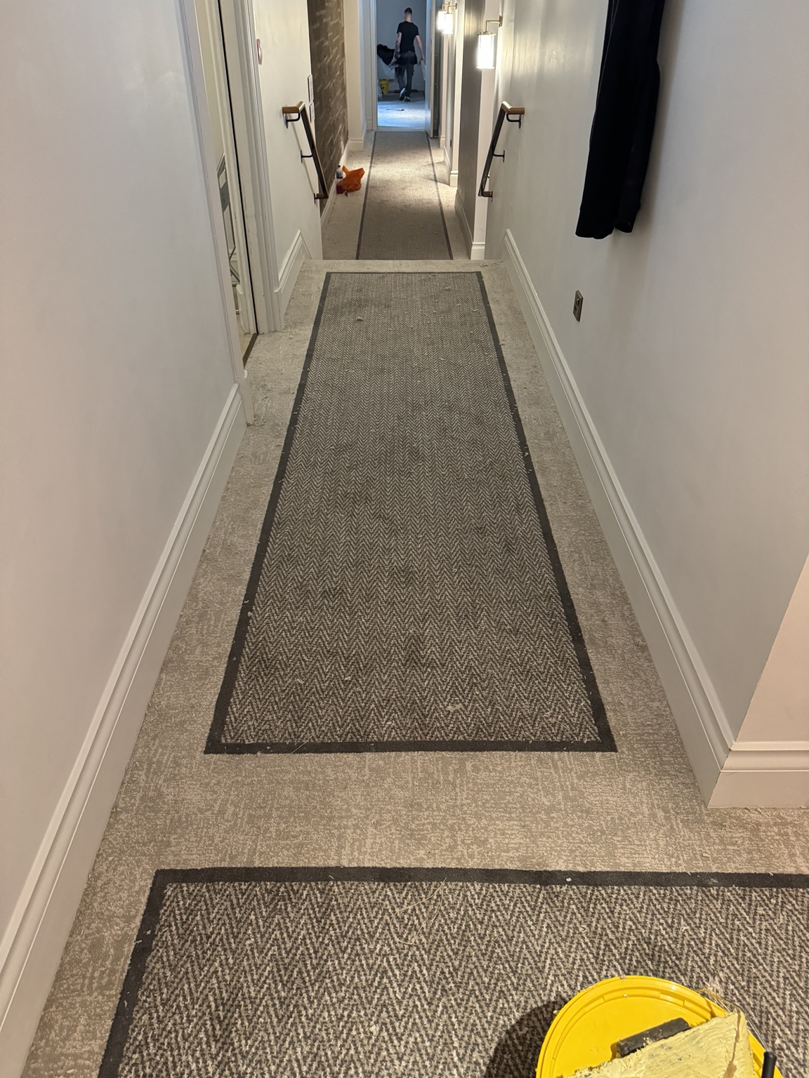 Herringbone carpet with a contrasting border fitted through a Virgin Hotel corridor