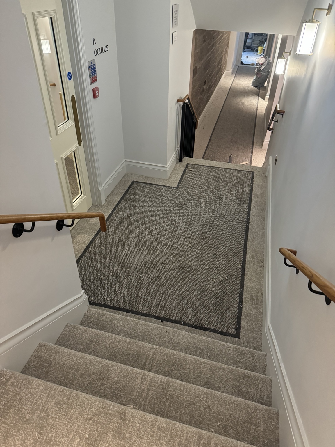 Border-designed carpet fitted across a Virgin Hotel stair landing and hallway